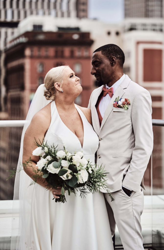 A bride and groom standing on the balcony of the Metropolitan on 9 in Cleveland, Ohio